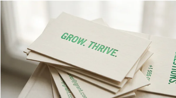 A close studio arrangement of custom business cards with distinctive green typography.