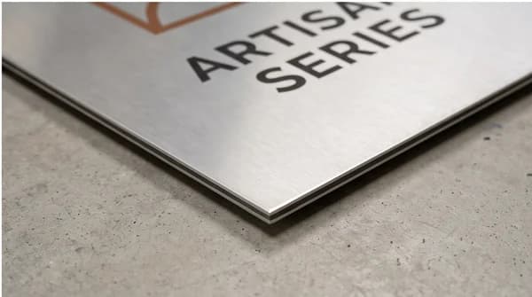 A close studio view of a custom printed metal board with its thin edge visible.