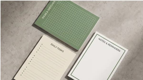 Several custom notepad layouts displayed together on a studio surface.