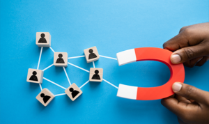 Magnet attracting user icons connected by lines, symbolizing digital lead generation and capture.