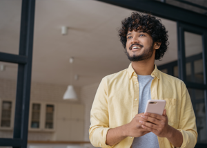 Happy customer holding smartphone, likely responding to a magnetic postcard offer or reminder.