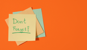 Layered sticky notes on an orange background with a handwritten “Don’t Forget!” reminder.