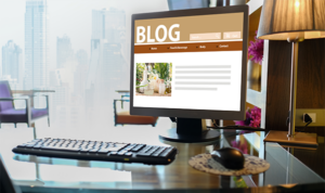 Computer monitor on a desk showing a personal blog interface with a navigation bar and article preview